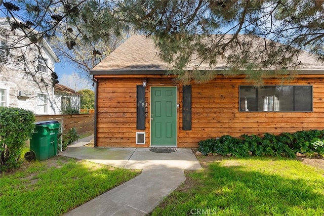 view of front of home with a front yard and roof with shingles