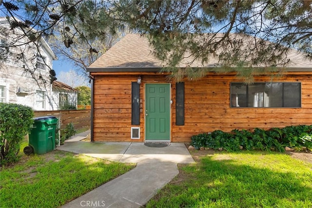view of front of property featuring roof with shingles and a front lawn