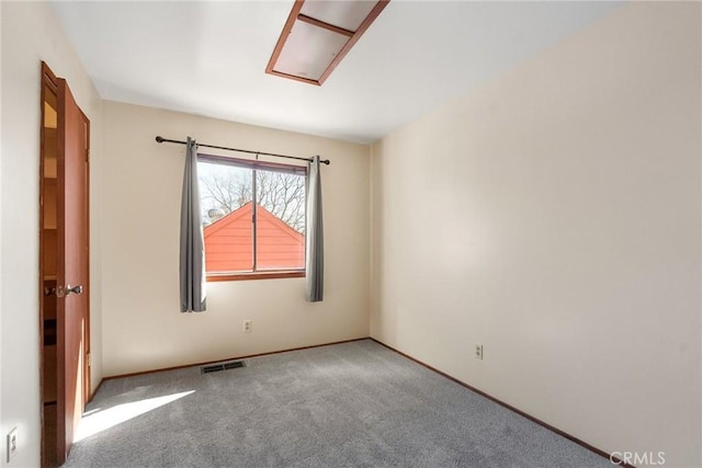 carpeted spare room featuring visible vents