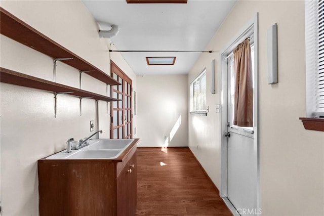 interior space featuring open shelves, a sink, and dark wood finished floors