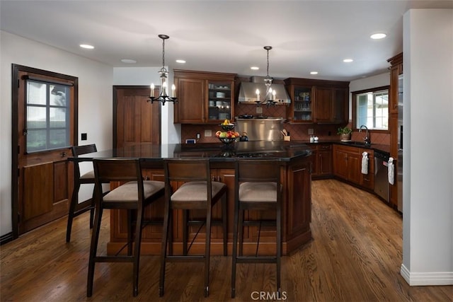 bar with tasteful backsplash, wall chimney range hood, dark wood finished floors, and pendant lighting