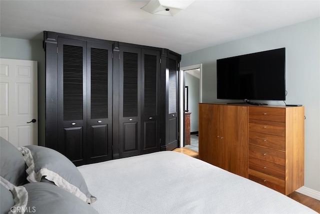 bedroom featuring wood finished floors and baseboards