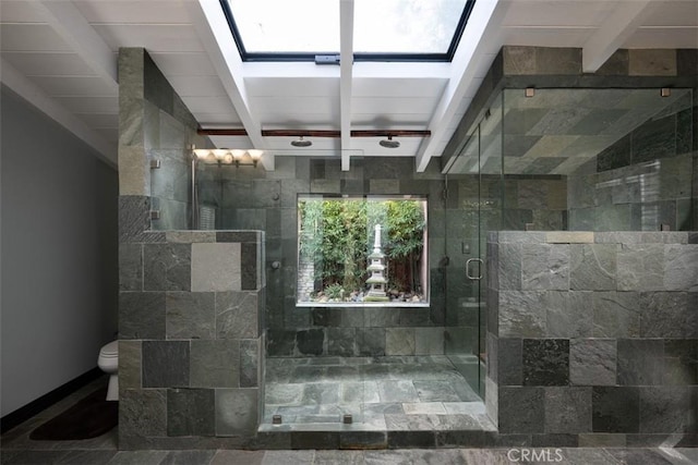 full bath with toilet, a stall shower, a skylight, and beamed ceiling