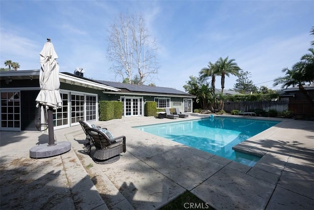 view of pool featuring french doors, a patio area, fence, and a fenced in pool