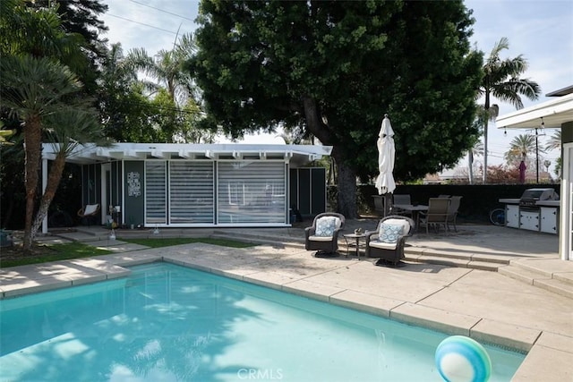 outdoor pool featuring a patio area, fence, and grilling area