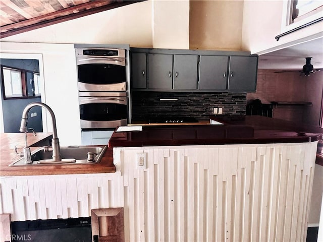 kitchen featuring double oven, sink, and backsplash