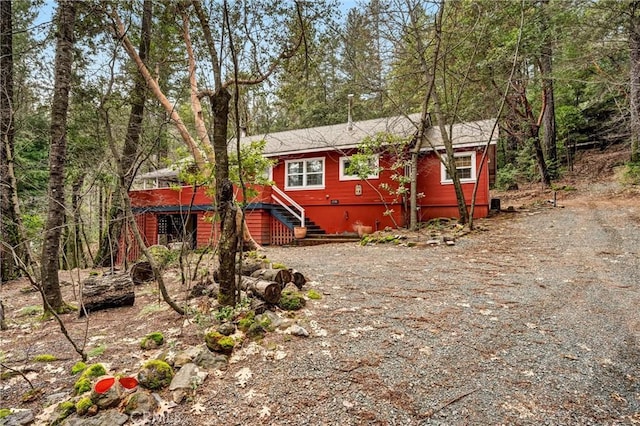 rustic home featuring driveway and stairway