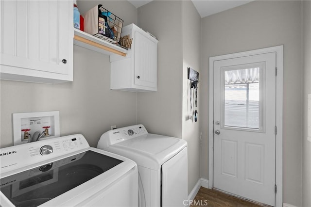 laundry room featuring washing machine and dryer, cabinets, and dark hardwood / wood-style flooring