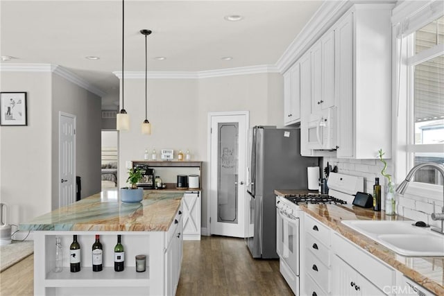 kitchen with white appliances, sink, a center island, white cabinetry, and hanging light fixtures