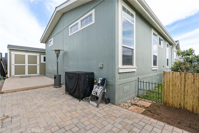 rear view of house with a storage unit and a patio area