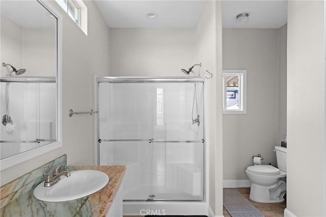 bathroom with vanity, toilet, and a shower with door