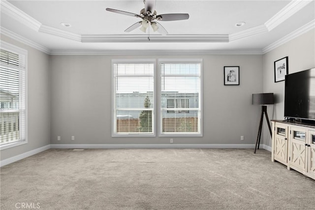 unfurnished living room featuring a raised ceiling, light carpet, and ornamental molding