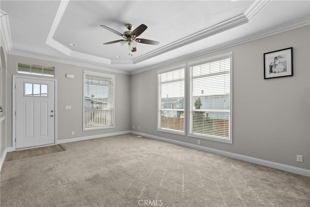 interior space featuring crown molding, a tray ceiling, and light colored carpet