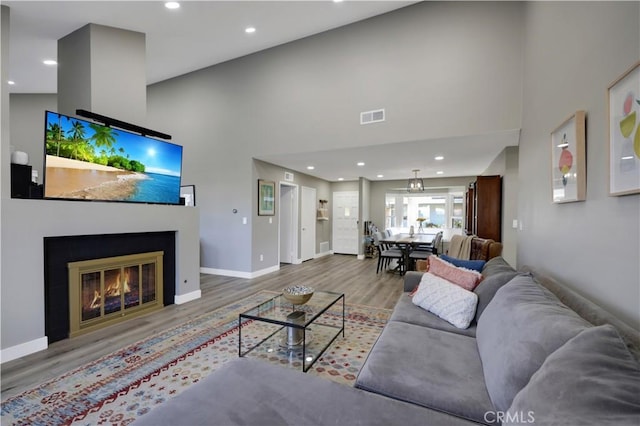 living room with high vaulted ceiling and hardwood / wood-style flooring