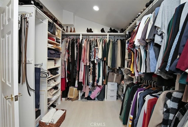 walk in closet with light hardwood / wood-style flooring and lofted ceiling