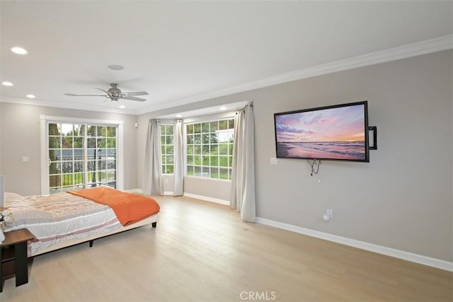 bedroom with multiple windows, ornamental molding, ceiling fan, and light hardwood / wood-style floors