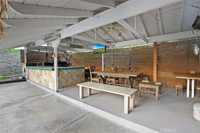 view of patio / terrace featuring ceiling fan and exterior bar