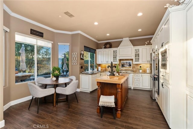 kitchen featuring crown molding, visible vents, backsplash, and a center island