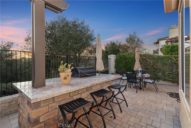 view of patio / terrace with outdoor dry bar, a grill, and fence