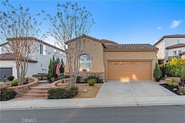 mediterranean / spanish-style house with driveway, stone siding, a tile roof, an attached garage, and stucco siding