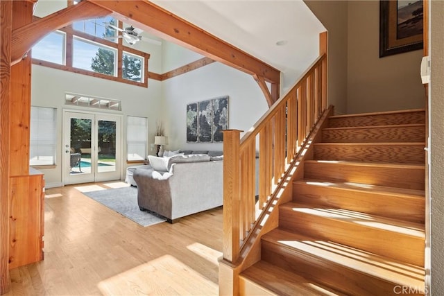 interior space with a wealth of natural light, high vaulted ceiling, wood finished floors, and french doors