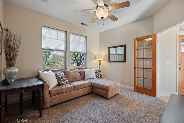 carpeted living area featuring ceiling fan, visible vents, and baseboards