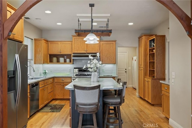 kitchen with ventilation hood, pendant lighting, stainless steel appliances, and light countertops