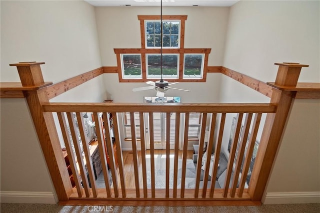 stairs featuring a ceiling fan