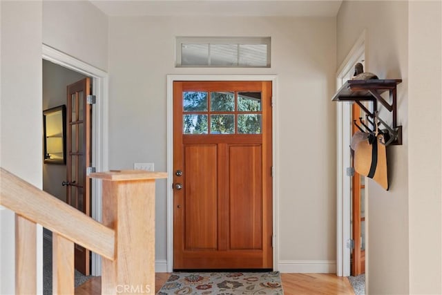 foyer entrance with light wood-style floors and baseboards