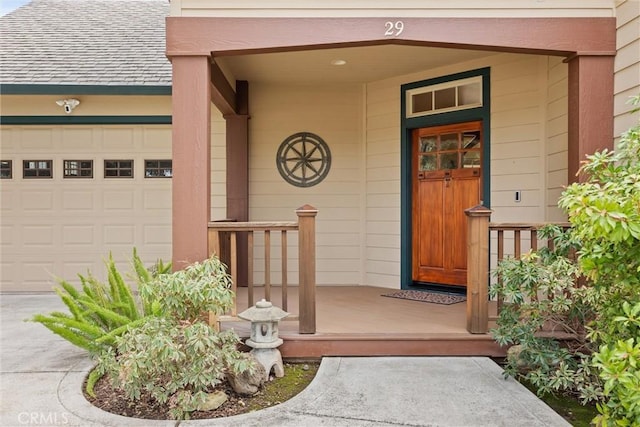 doorway to property featuring a porch, a shingled roof, and an attached garage