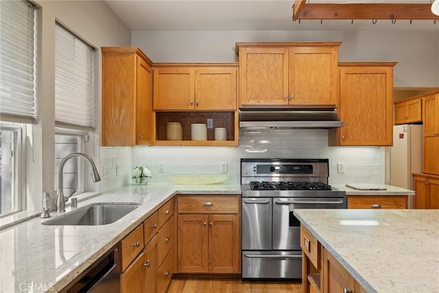 kitchen featuring light stone countertops, under cabinet range hood, a sink, double oven range, and open shelves