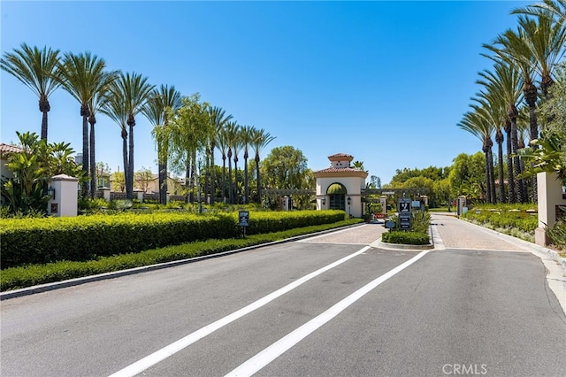 view of road featuring curbs, a gated entry, and a gate