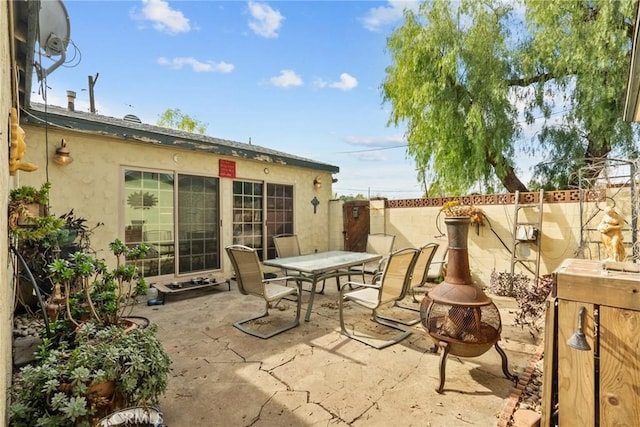 view of patio / terrace featuring a fire pit, outdoor dining area, and a fenced backyard