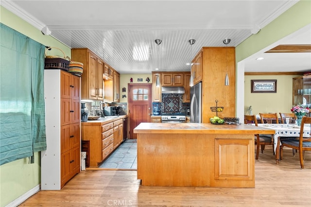 12626 Cometa Ave, San Fernando, CA 91340 - kitchen with under cabinet range hood, stainless steel appliances, a peninsula, a sink, and backsplash