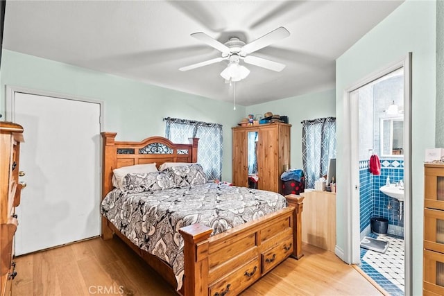 bedroom with ensuite bath, light wood-style floors, and ceiling fan