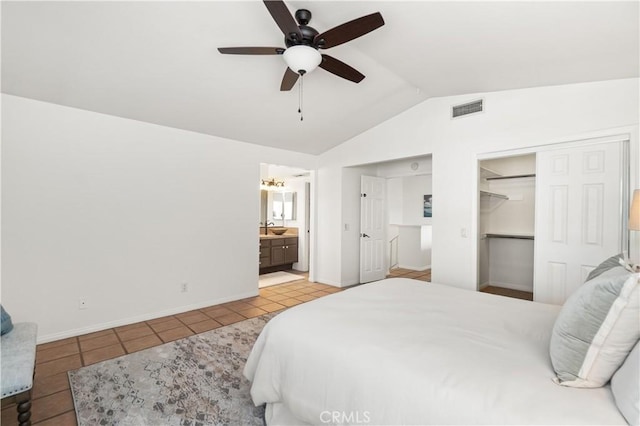 bedroom featuring visible vents, light tile patterned floors, vaulted ceiling, ensuite bathroom, and a sink