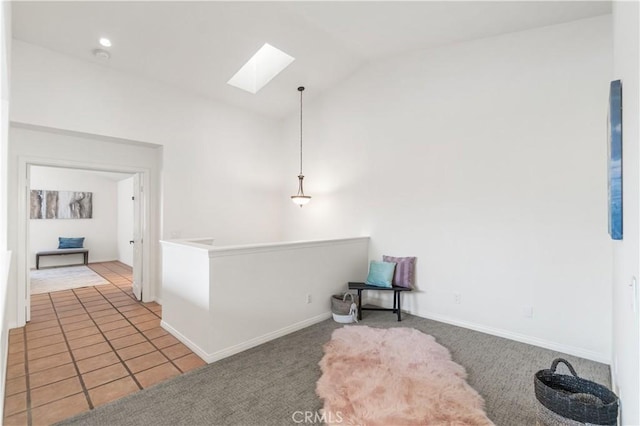 living area with light colored carpet, vaulted ceiling with skylight, baseboards, light tile patterned flooring, and an upstairs landing