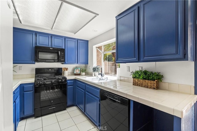 kitchen with blue cabinets, black appliances, a sink, and light tile patterned flooring