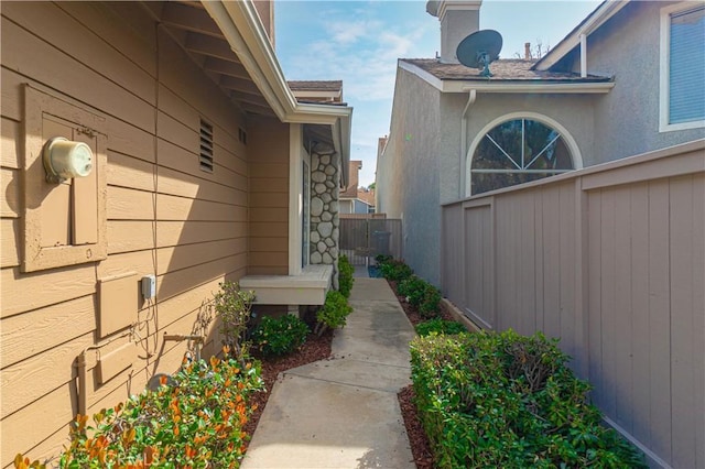 view of side of property featuring fence and stucco siding