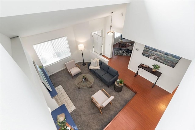 living room featuring baseboards, dark wood finished floors, and vaulted ceiling