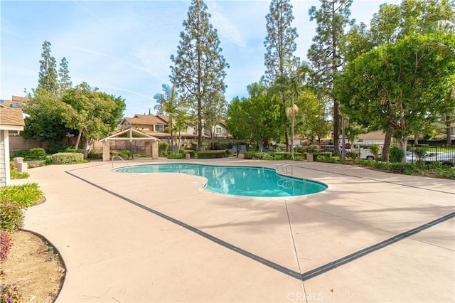 community pool featuring a patio and fence