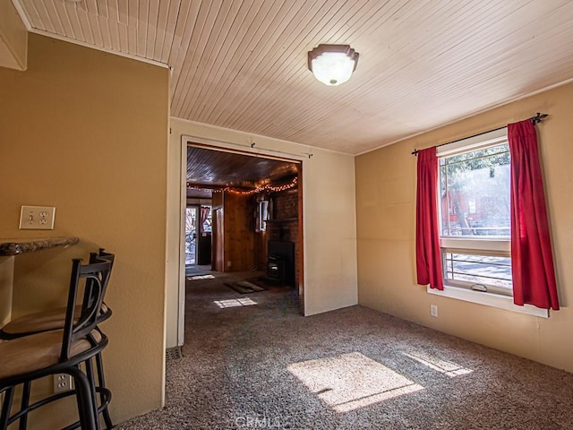 interior space with dark carpet, wooden ceiling, and a healthy amount of sunlight