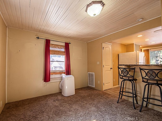 carpeted spare room with wood ceiling