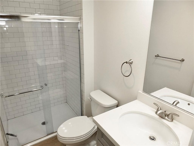 full bath featuring a stall shower, vanity, and toilet