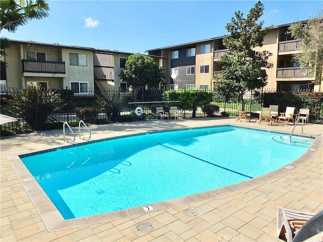 pool featuring fence and a patio