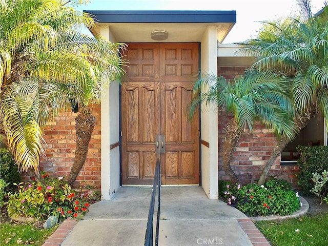 doorway to property featuring brick siding