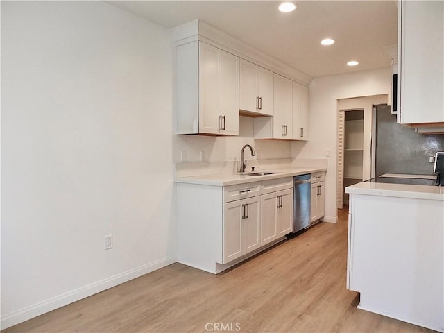 kitchen featuring stove, a sink, baseboards, dishwasher, and light wood finished floors