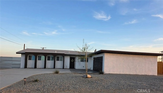 single story home featuring driveway, an attached garage, and stucco siding