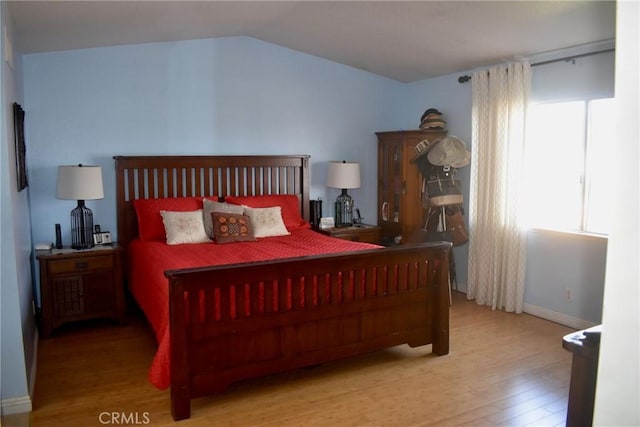 1041 E Riverside Dr, Ontario, CA 91761 - bedroom with multiple windows, baseboards, vaulted ceiling, and wood finished floors