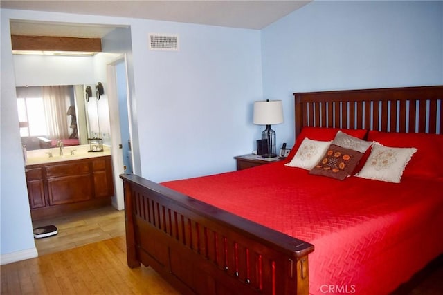 1041 E Riverside Dr, Ontario, CA 91761 - bedroom with light wood finished floors, ensuite bath, a sink, and visible vents
